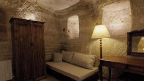 A cozy room with a bed, a wooden cabinet, and a lamp. - Memory Cave House (Nevsehir)