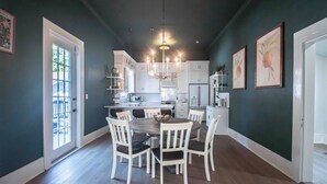 Une cuisine moderne avec des meubles blancs, un îlot central et un lustre.