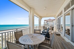 A wooden deck with a round table and chairs, overlooking a beach and ocean. - Turtle Tracks: Beachfront, East End, Pet Friendly, Sunset Beach (St. George Island)