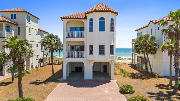 A beachfront property with a central building featuring balconies and a covered entrance. - Turtle Tracks: Beachfront, East End, Pet Friendly, Sunset Beach (St. George Island)