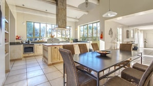 Una cocina amplia con comedor, ventanas grandes y un techo alto con vigas a la vista.