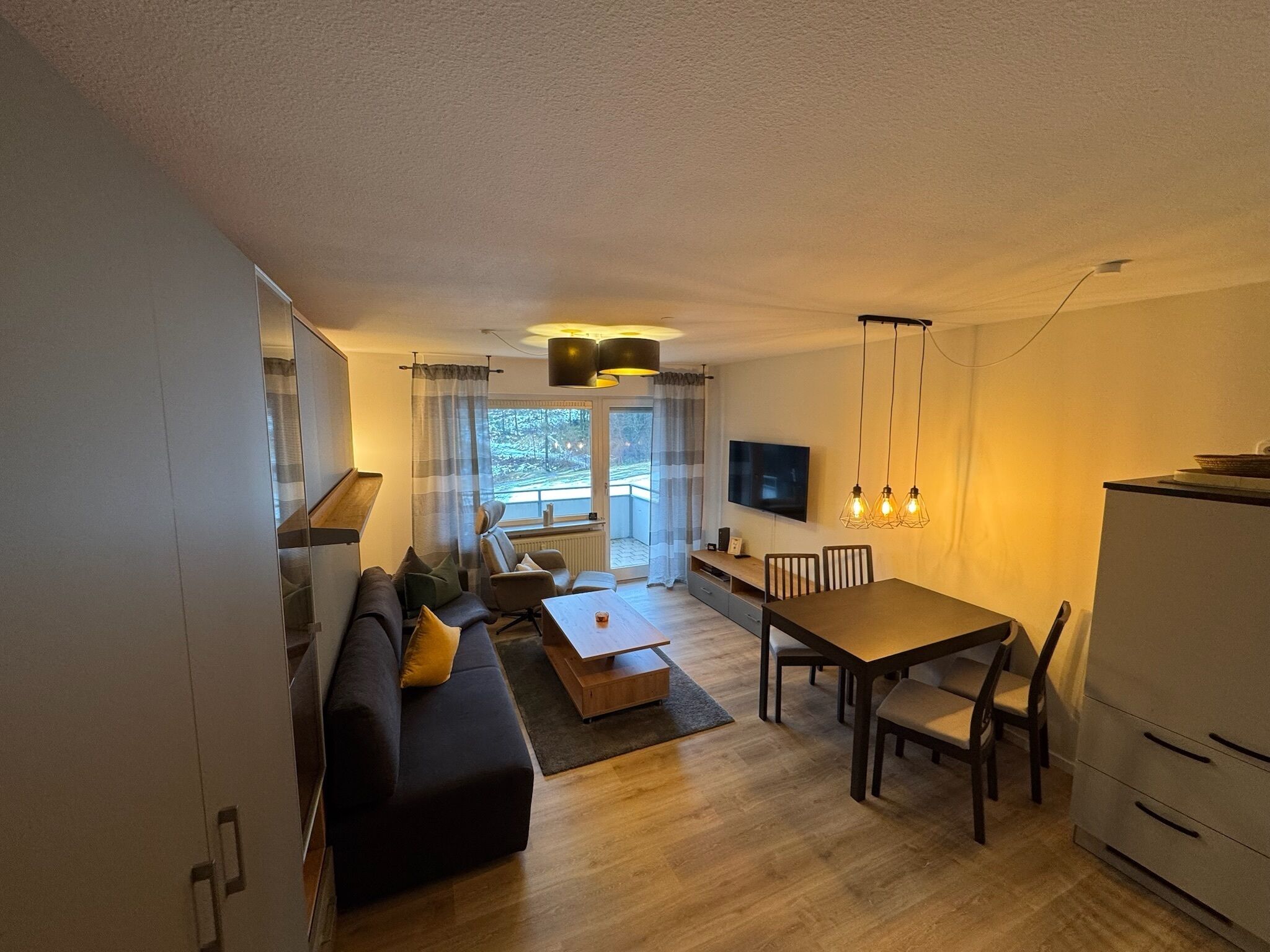 Ein modernes Wohnzimmer mit Sofa, Couchtisch und Essbereich.