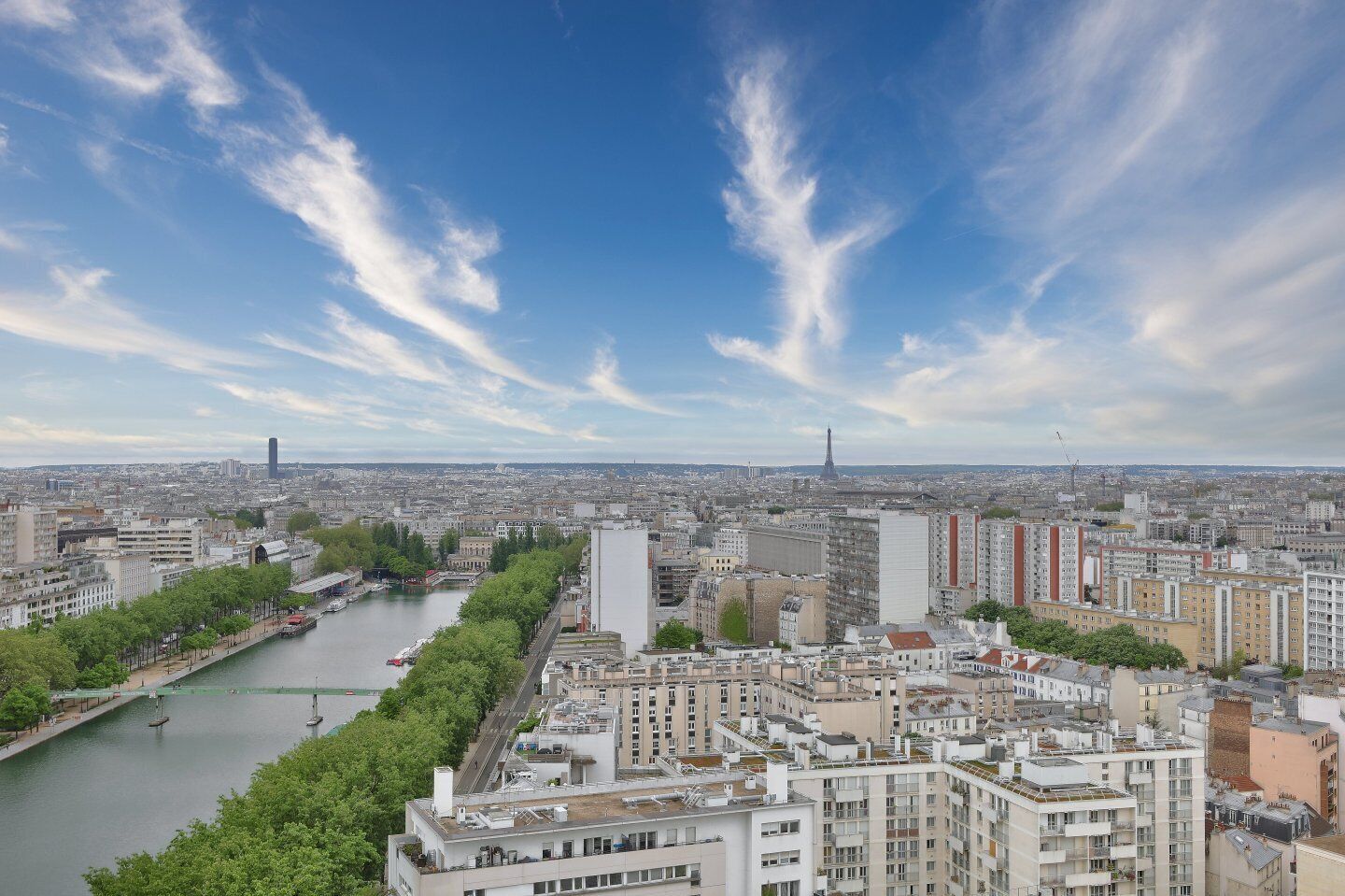 A cityscape with a river, buildings, and a distant tower.