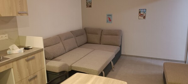 A compact room with a sofa bed, a small table, and a cabinet. - Studio with pool, refurbished, ideally located (Le Diamant)