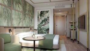A modern hotel room with a bed, a round table with a bottle and glass, a green armchair, a large wall mural, and a TV mounted on the wall. - ibis Styles Istanbul Kurtkoy (Istanbul)