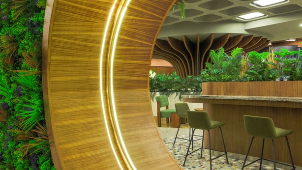 A modern interior with a curved wooden wall, green chairs, and a bar area. - ibis Styles Istanbul Kurtkoy (Istanbul)