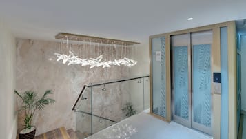 Um interior moderno com parede de mármore, guarda-corpo de vidro e painéis decorativos.
