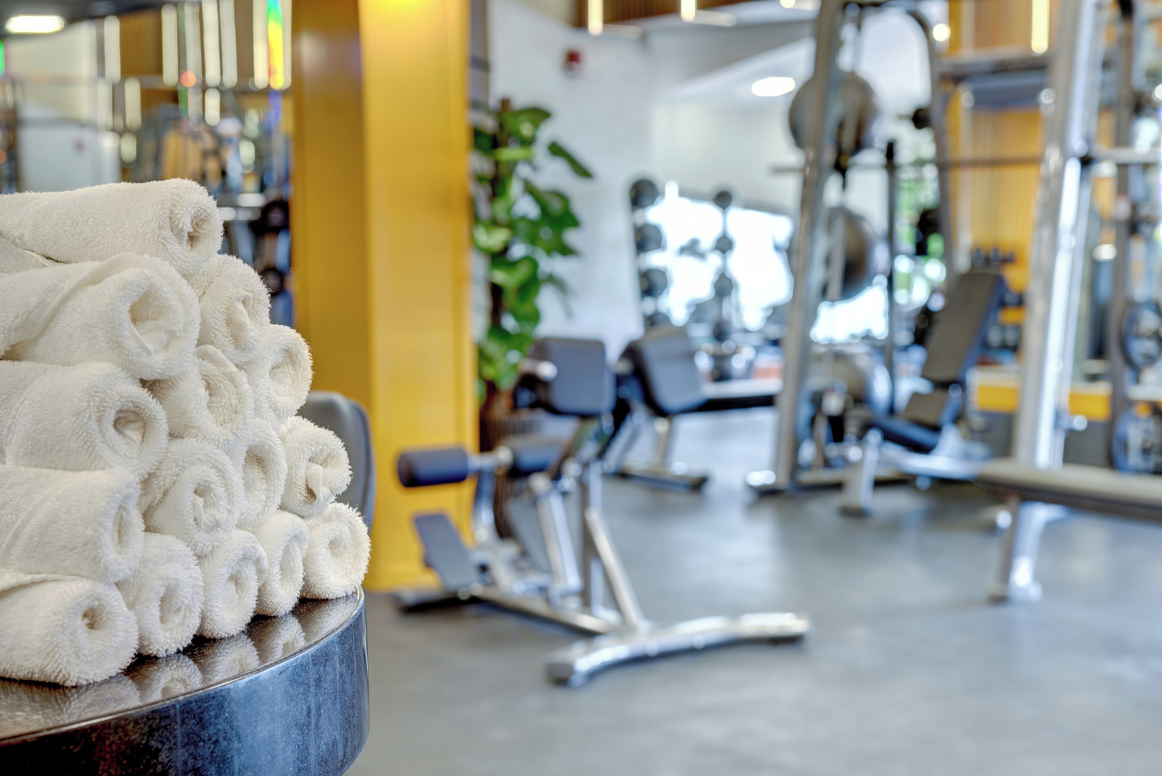 A gym with exercise equipment and a stack of white towels.