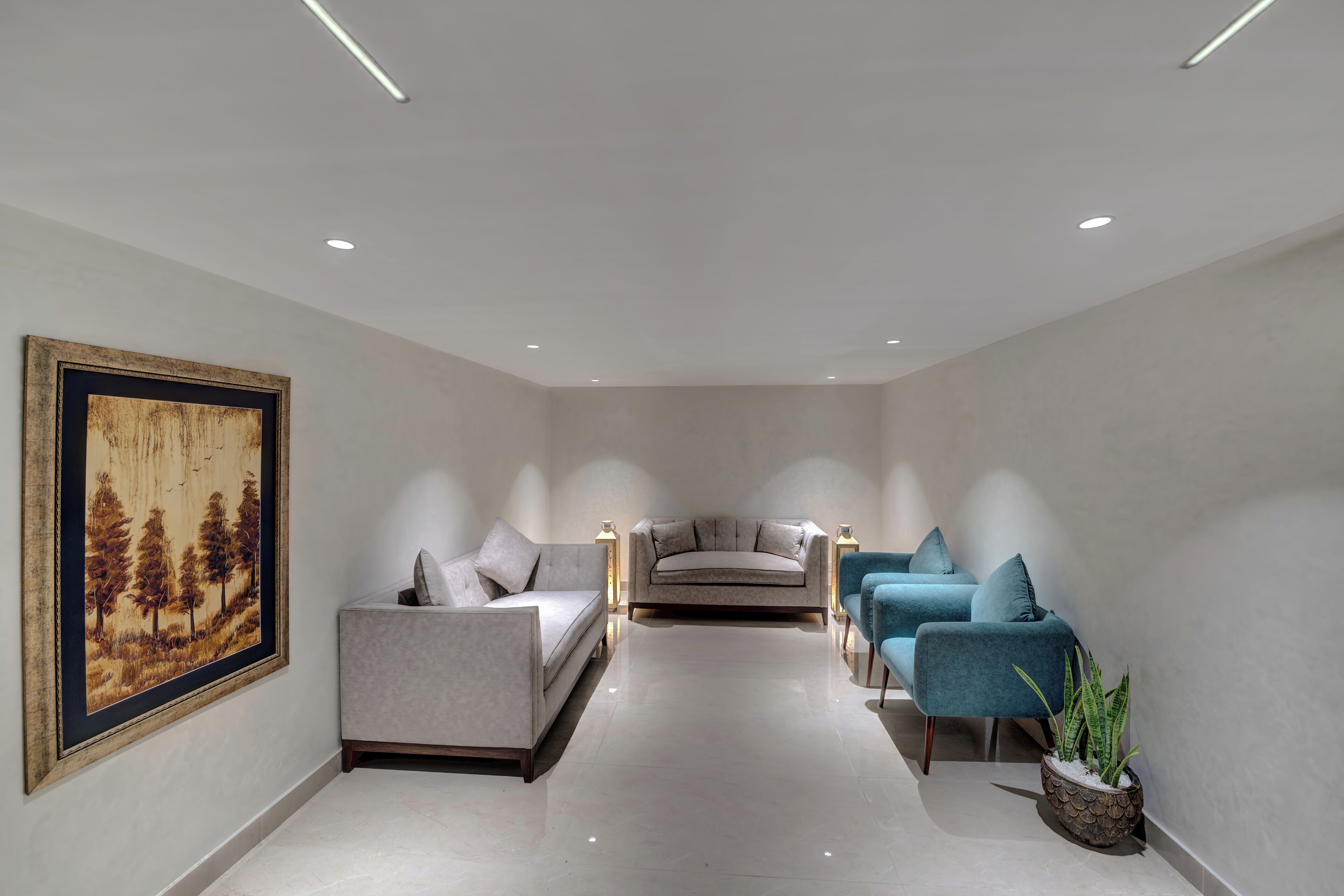Een moderne woonkamer met een bank, fauteuils en een schilderij aan de muur.