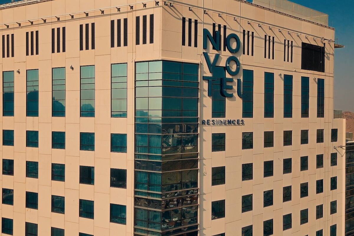 Een modern gebouw met een beige gevel en veel ramen. De naam “NOVOTEL” staat duidelijk op de zijkant.