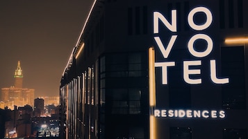 Un edificio con señalización iluminada que dice "NOVOTEL RESIDENCES".