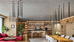A modern interior with a dining area, kitchen, and seating. - Novotel Residences Makkah (Makkah)