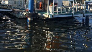 Una casa flotante con terraza techada y un paraguas.