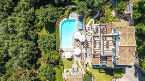 Vue aérienne d’un complexe hôtelier doté d’une piscine, d’un espace de détente en plein air et d’un bâtiment à étages.