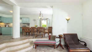 Un vaste espace de vie comprenant une table à manger, des chaises, un banc et un fauteuil.