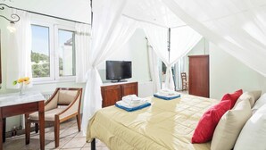 Une chambre à coucher avec un lit, une télévision, un bureau et une chaise.