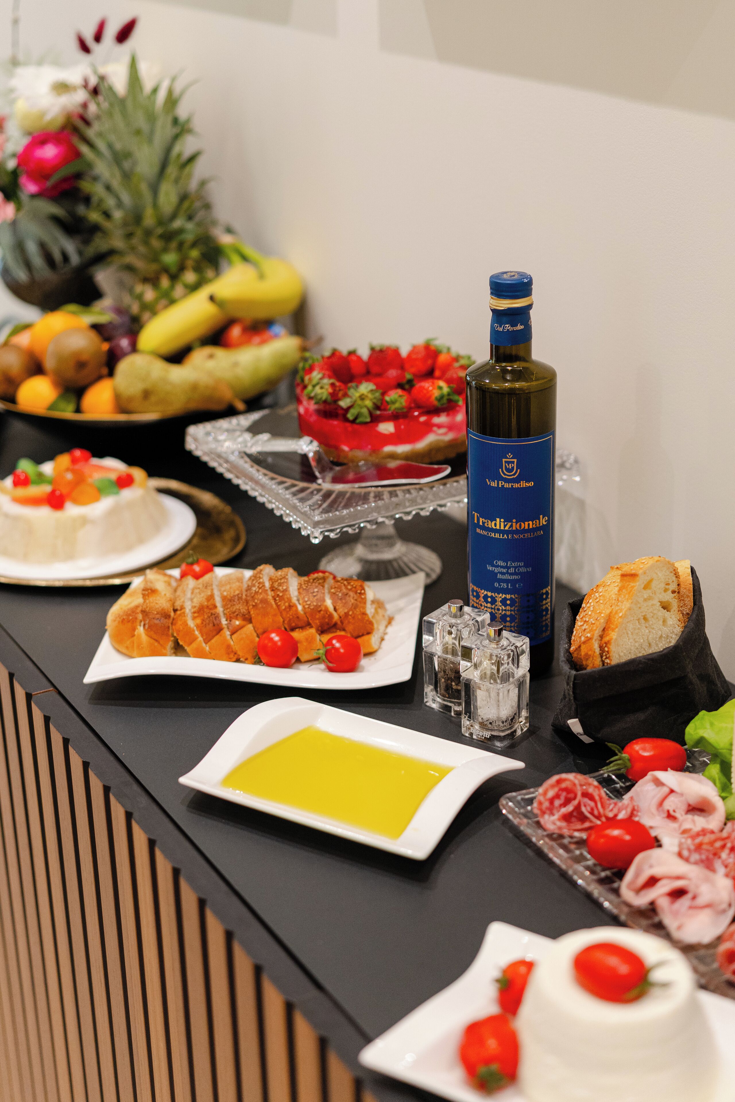 Un bufet amb diferents aliments, com fruita, formatge i pa.