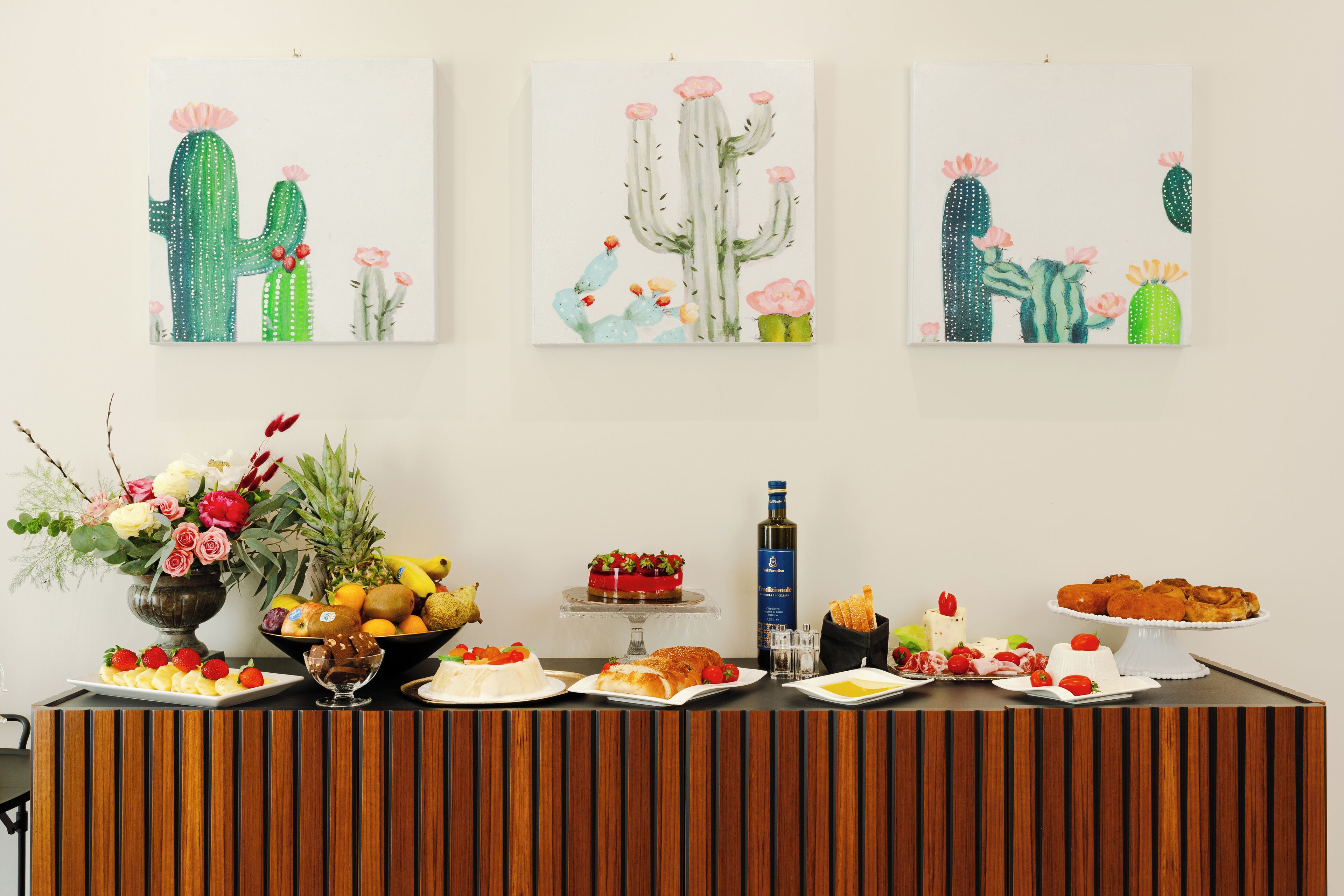 A reception area with a wooden reception desk, a vase of flowers, and a fruit bowl.