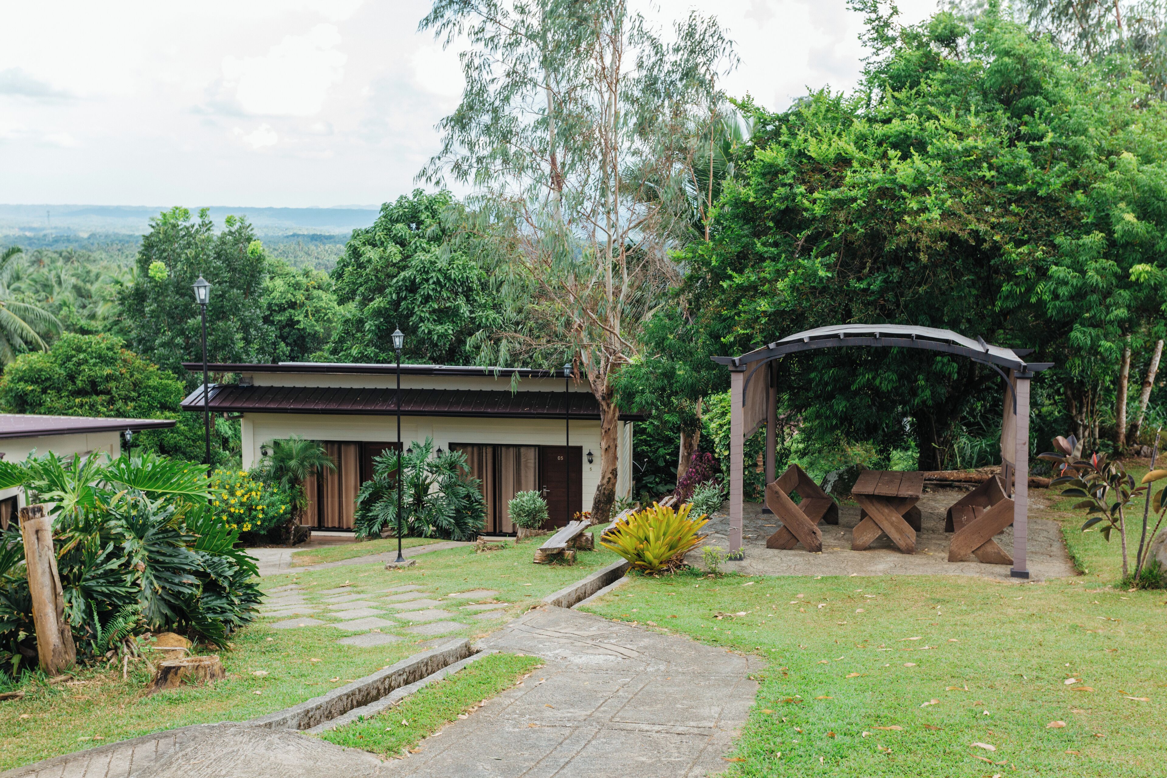 A house with a garden, a wooden deck, and a stone pathway leading to the entrance.
