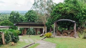 A house with a garden, a wooden deck, and a stone pathway leading to the entrance.