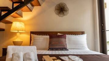 Habitación de hotel con cama, lámpara, un adorno en la pared y ventana.