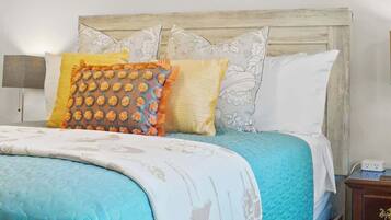 Una cama con estructura de madera, cabecera y mesita de noche con lámpara.