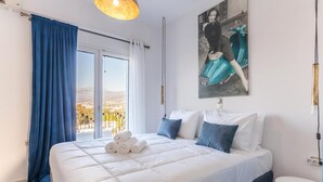 Een slaapkamer met een groot bed, uitzicht op de omgeving en een schilderij aan de wand.