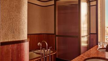 Une salle de bain avec un grand miroir, un lavabo et un espace douche.