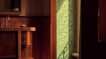 Un bagno con un mobile lavabo in legno, uno specchio e una tenda da doccia fantasia.