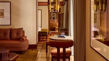 A cozy room with a leather sofa, a wooden coffee table, and a dining area with a chair and table.
