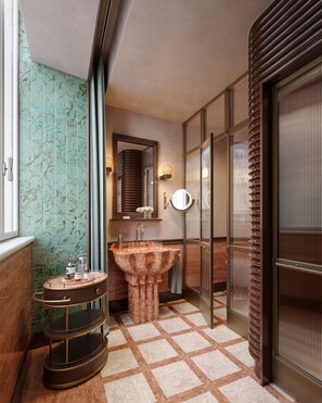 Une salle de bain avec un lavabo en marbre, un miroir rond et une coiffeuse avec un miroir.