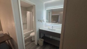 Une salle de bain avec une douche, des toilettes et un lavabo avec un miroir.