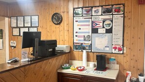 Un comptoir d’accueil équipé d’un ordinateur, d’une imprimante et de divers panneaux d’information, notamment une frise chronologique et des données sur l’État de l’Ohio.