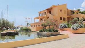 A Mediterranean-style building with a courtyard, a small pond, and potted plants. - - BayAltea (Altea)