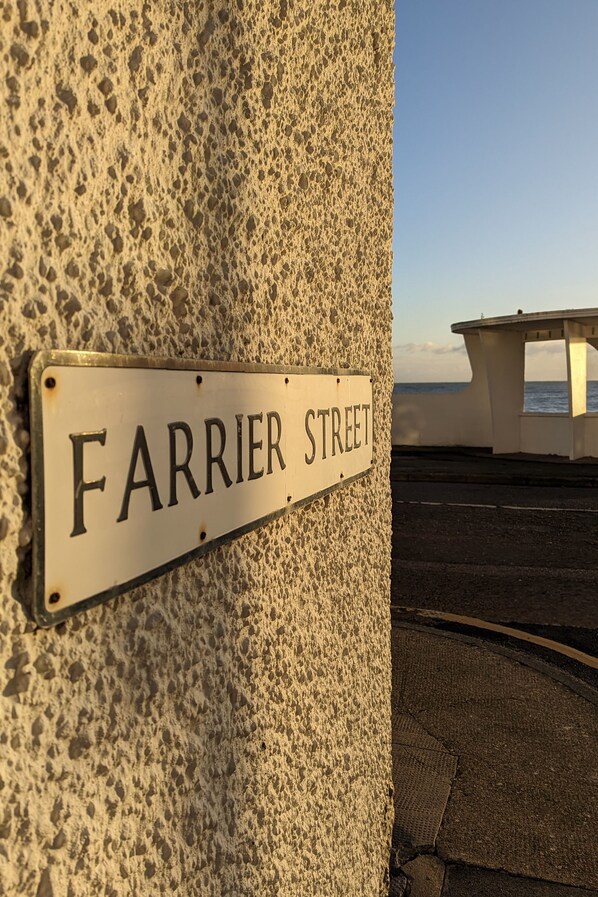 A street sign reading "FARRIER STREET" mounted on a textured wall.