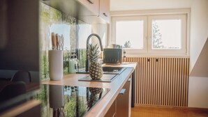 A modern kitchen with a wooden countertop, a pineapple, and a knife holder.
