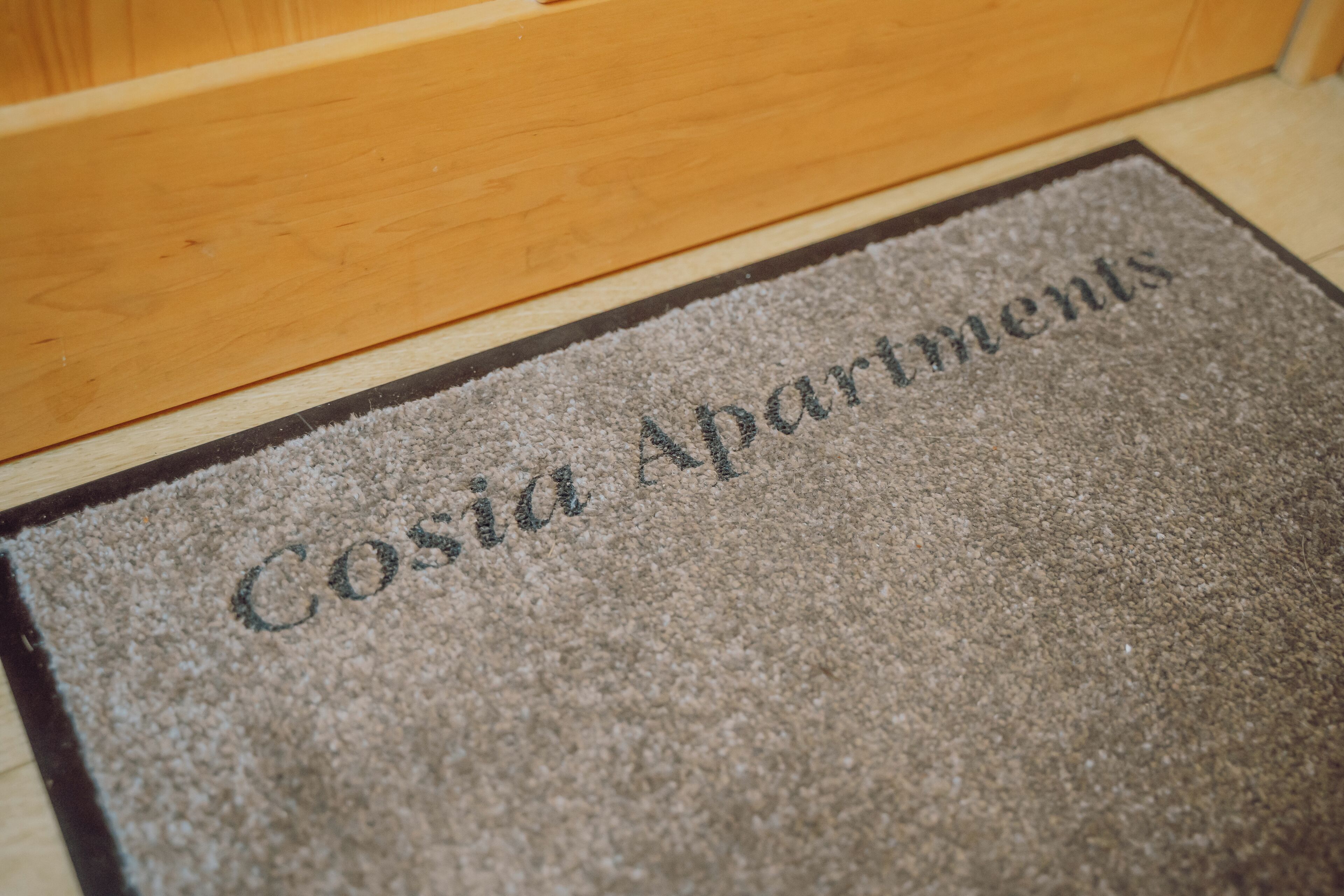 Un paillasson avec l’inscription « Cosia Apartments ».