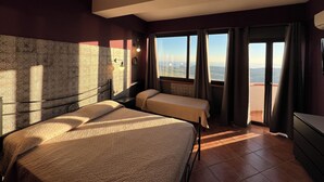 A hotel room with two beds, a view of the cityscape, and a balcony with curtains. - B&B Monte (Giardina Gallotti)