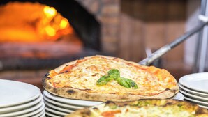 A pizza oven with pizzas being cooked. - B&B Monte (Giardina Gallotti)