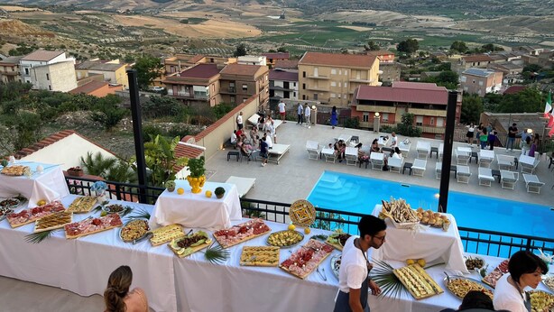 A terrace with a pool, surrounded by a scenic view of hills and a coastal landscape. - B&B Monte (Giardina Gallotti)