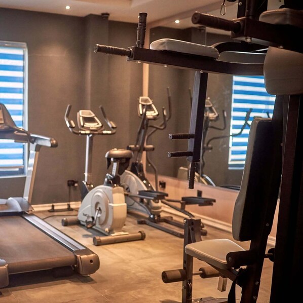 A gym with exercise equipment including treadmills, stationary bikes, and weight machines.