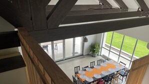 A dining area with a long table, chairs, and a potted plant. - MAISON DE VACANCES près de Thermes de Bucarest & Otopeni Airport (Balotesti)