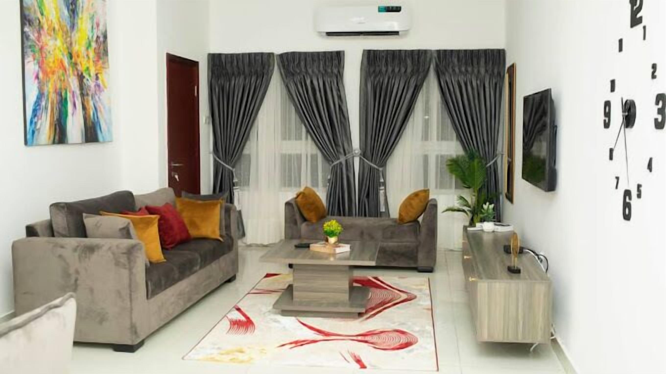 A modern living room with a grey sofa, a coffee table, and a TV on a stand.