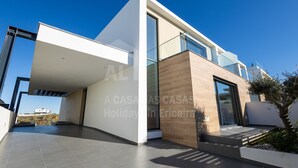 A modern two-story house with a flat roof, large glass windows, and a spacious balcony. - Casa Mango by Acasadascasas (Mafra)