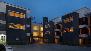 Um edifício moderno de vários andares, com amplas janelas e um pátio.