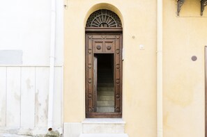 Un edificio con puerta de madera y una pequeña ventana encima.