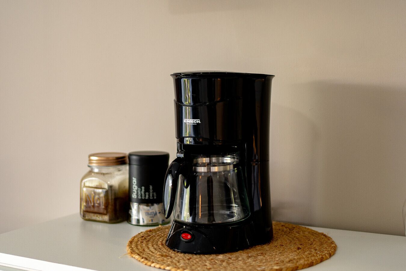 Een koffiezetapparaat op een geweven onderzetter.