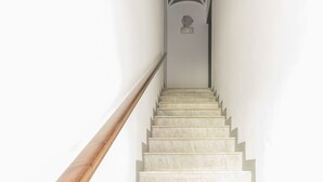 A staircase with a wooden handrail and a white wall. - Visitsicilia Le Magnolie 4 (Castellammare del Golfo)