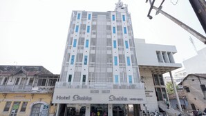 A hotel with a modern facade, featuring a central vertical strip and multiple windows. - Hotel Bhabha (Rajkot)
