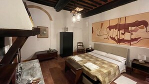 Una habitación con cama, escritorio, silla, armario y un cuadro en la pared.